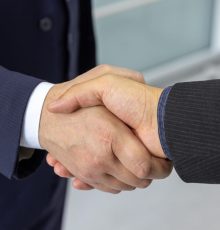 Close-up of two business professionals shaking hands, symbolizing partnership and collaboration.